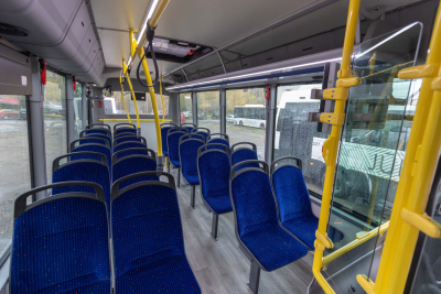 Jauna autobusa salons ar zilām sēdvietām un dzelteniem rokturiem
