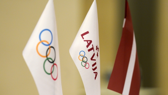 Latvijas olimpiskās komitejas un Latvijas karodziņi uz galda