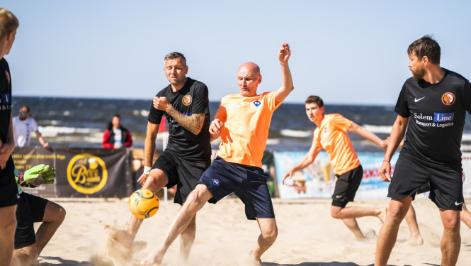 Četri vīrieši spēlē futbolu un piedalās Jūrmalas kausā pludmales futbolā