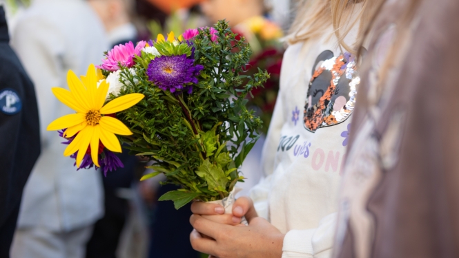 skolēns ar ziediem rokās