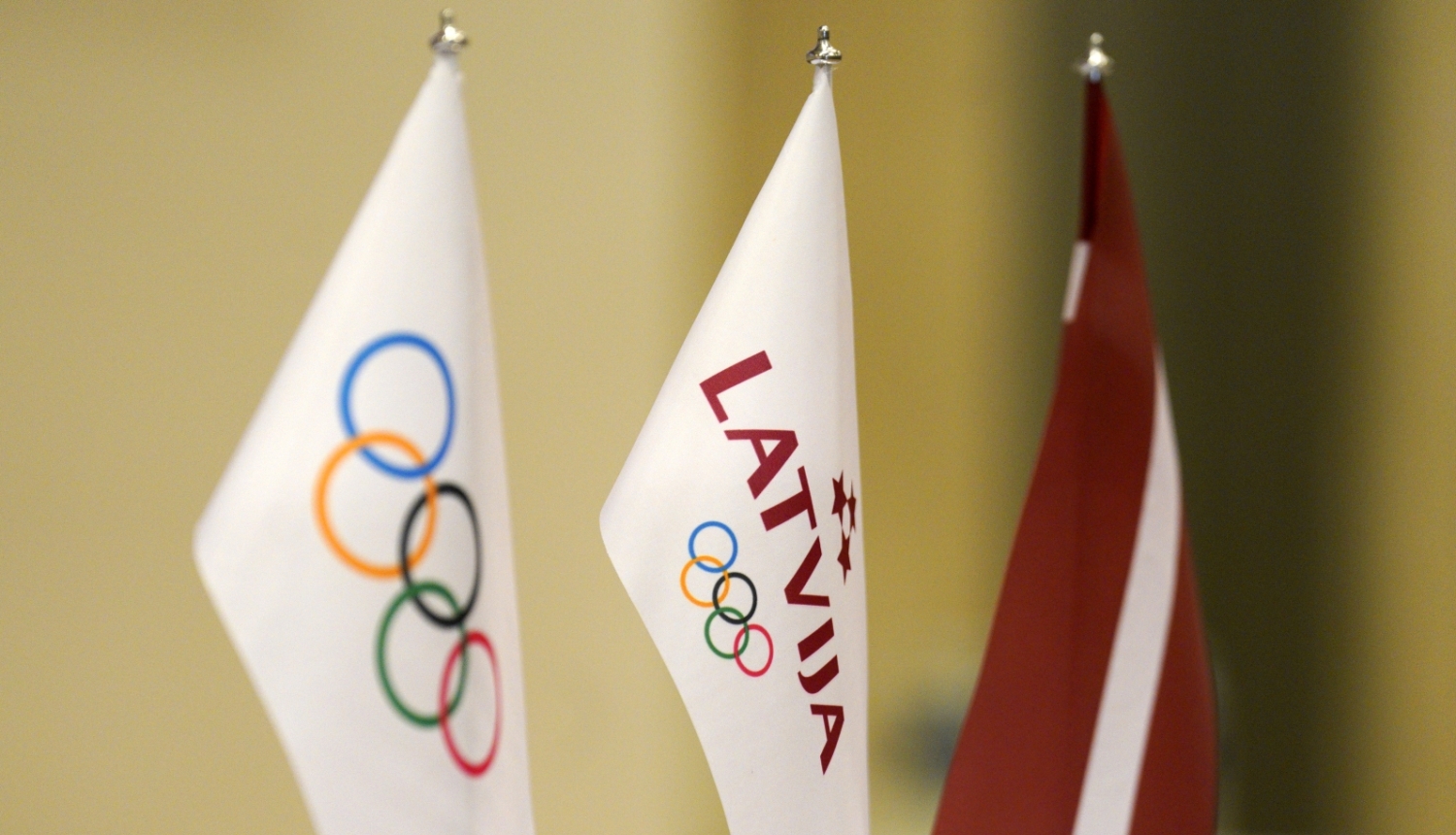 Latvijas olimpiskās komitejas un Latvijas karodziņi uz galda