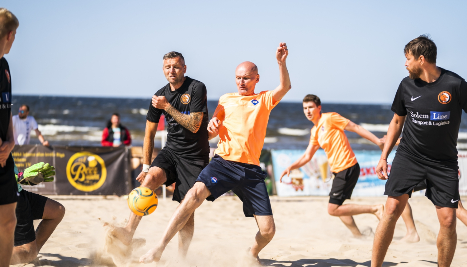 Četri vīrieši spēlē futbolu un piedalās Jūrmalas kausā pludmales futbolā