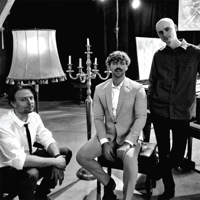 Trīs vīrieši pozē ekrānam