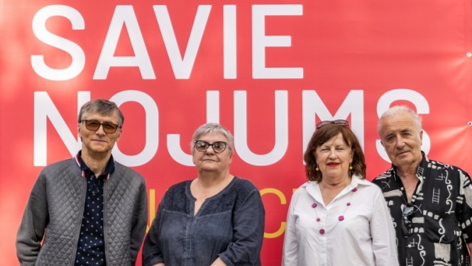 Talsu Krūmu grupas mākslinieki pie Valda Buša  100-gades izstādes Savienojums plakāta 2024. gada 30. maijā. No kreisās: Andris Vītols, Gunta Kalsere, Guna Millersone, Andris Biezbārdis. Foto: Ieva Romaško