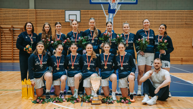 Jūrmalas Sporta skolas meiteņu komanda ar medaļām un treneris Kaspars Bože.