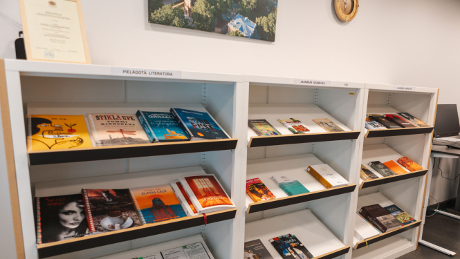 Šajā attēlā redzamas grāmatu plauktu rindas bibliotēkā