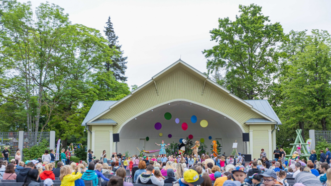 Mellužu estrāde vasaras dienā kurā norisinās bērnu koncerts, fonā bērni