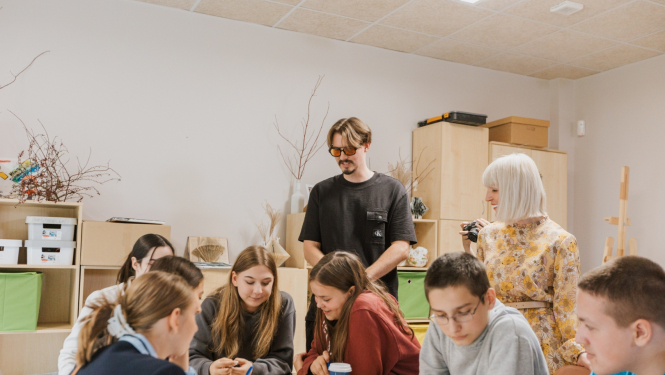 Jaunieši pie galda Jauniešu mājā Kauguros