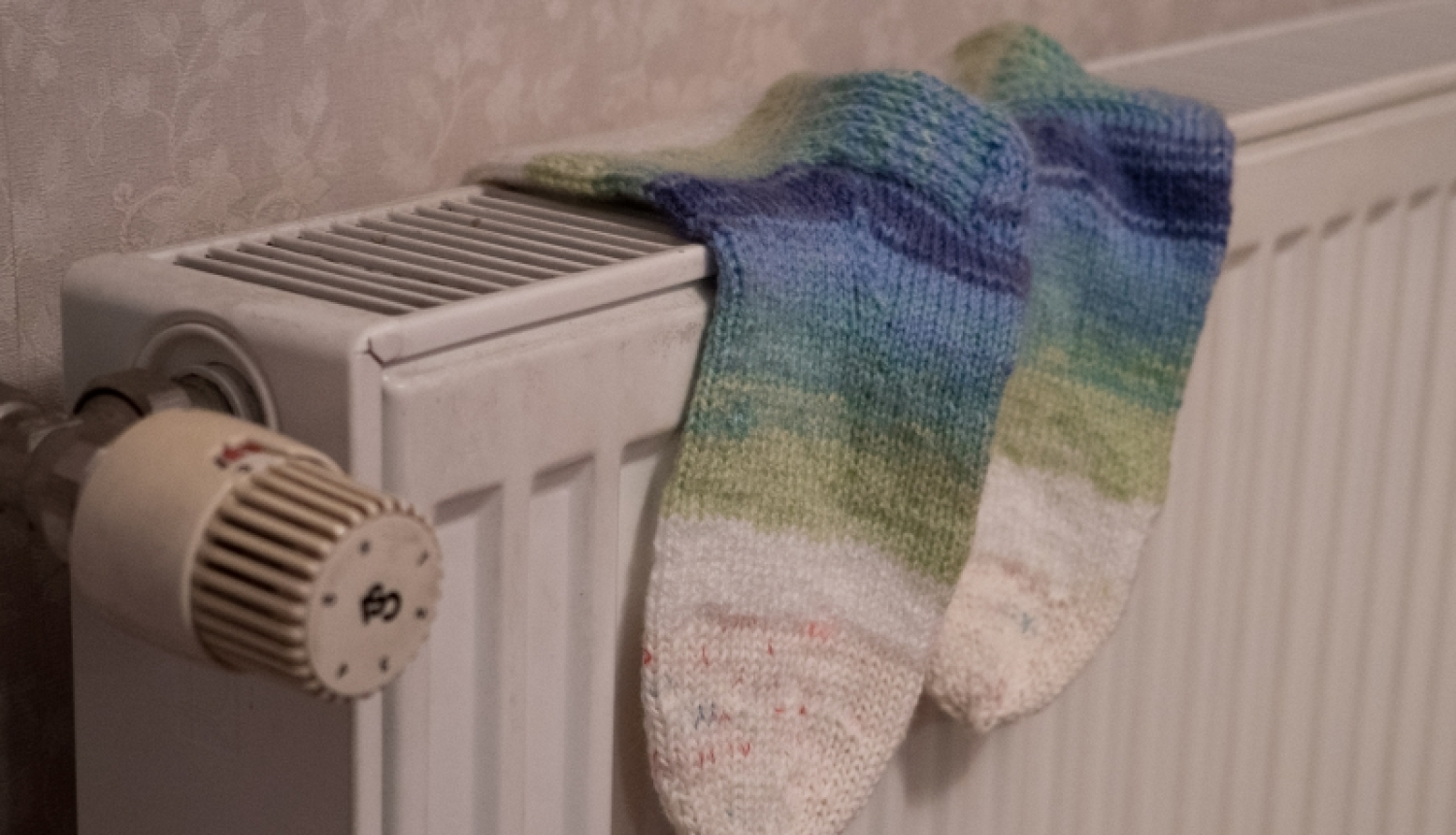 uz radiatora žāvējas zeķes