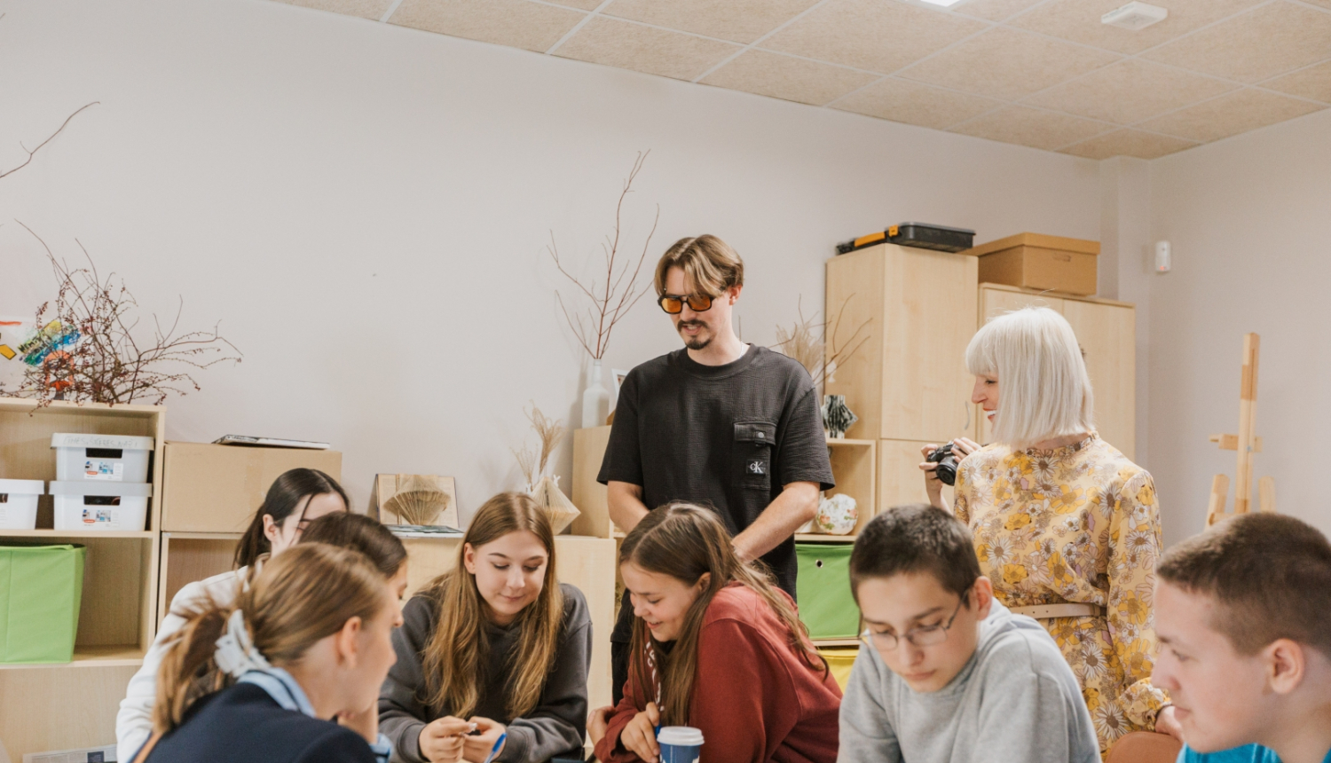 Jaunieši pie galda Jauniešu mājā Kauguros