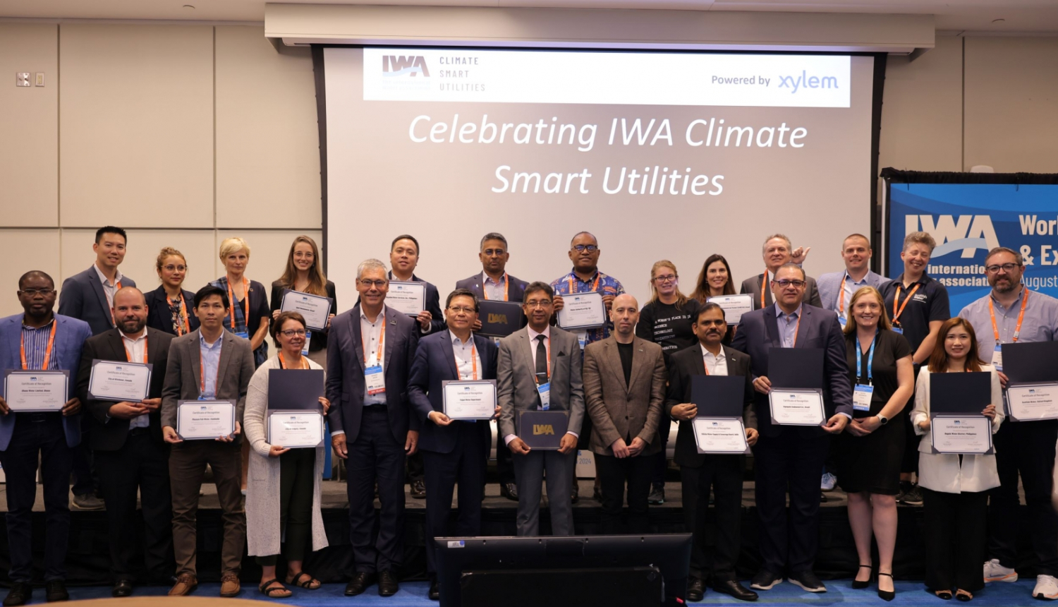 Klimatviedas ūdenssaimniecības sertifikāti tika piešķirti 28 ūdenssaimniecības uzņēmumiem no dažādām valstīm. Otrajā rindā trešais no labās – SIA “Jūrmalas ūdens” Ģeogrāfiskās informācijas sistēmas daļas vadītājs Gints Dakša