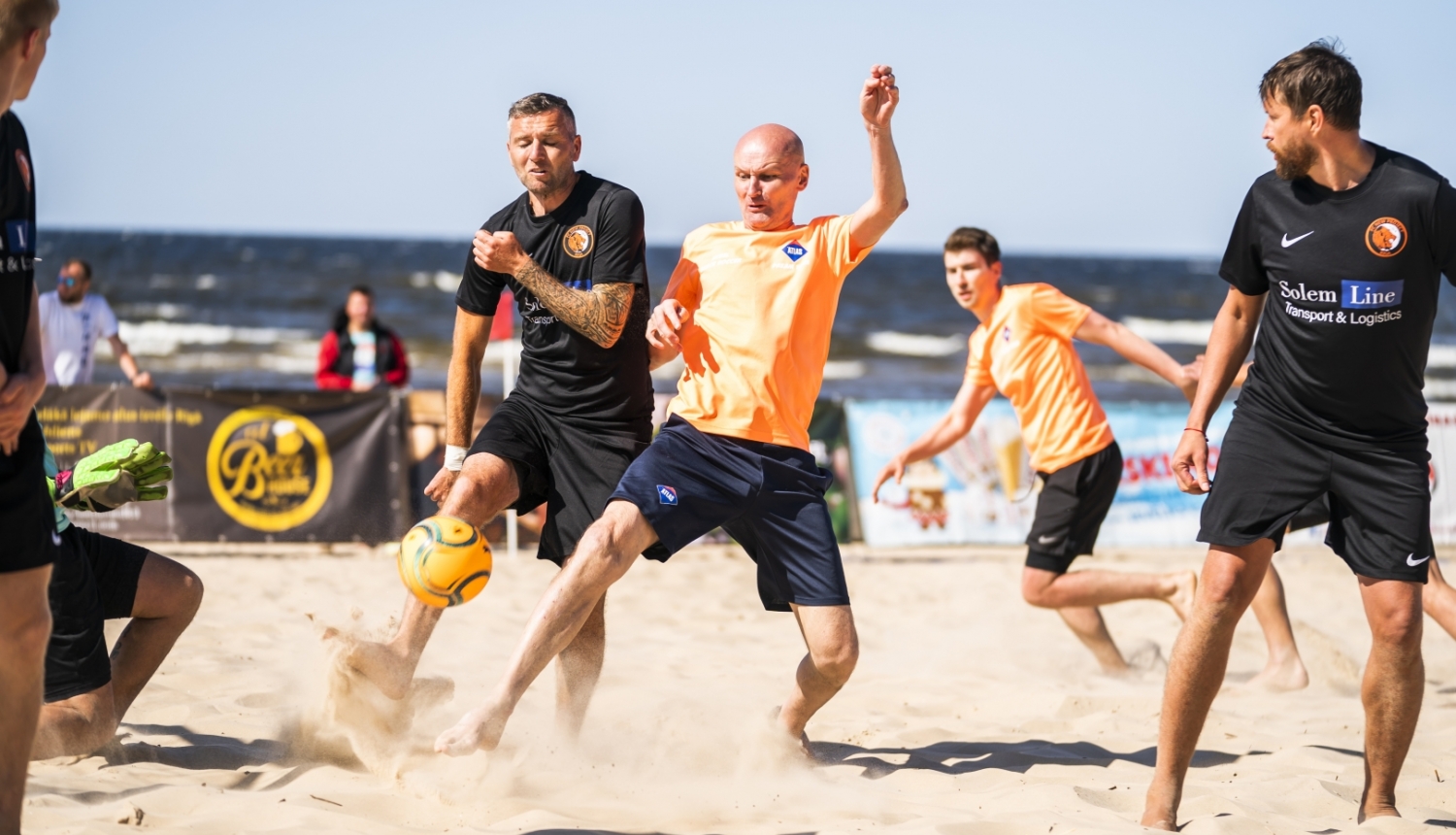 Četri vīrieši spēlē futbolu un piedalās Jūrmalas kausā pludmales futbolā