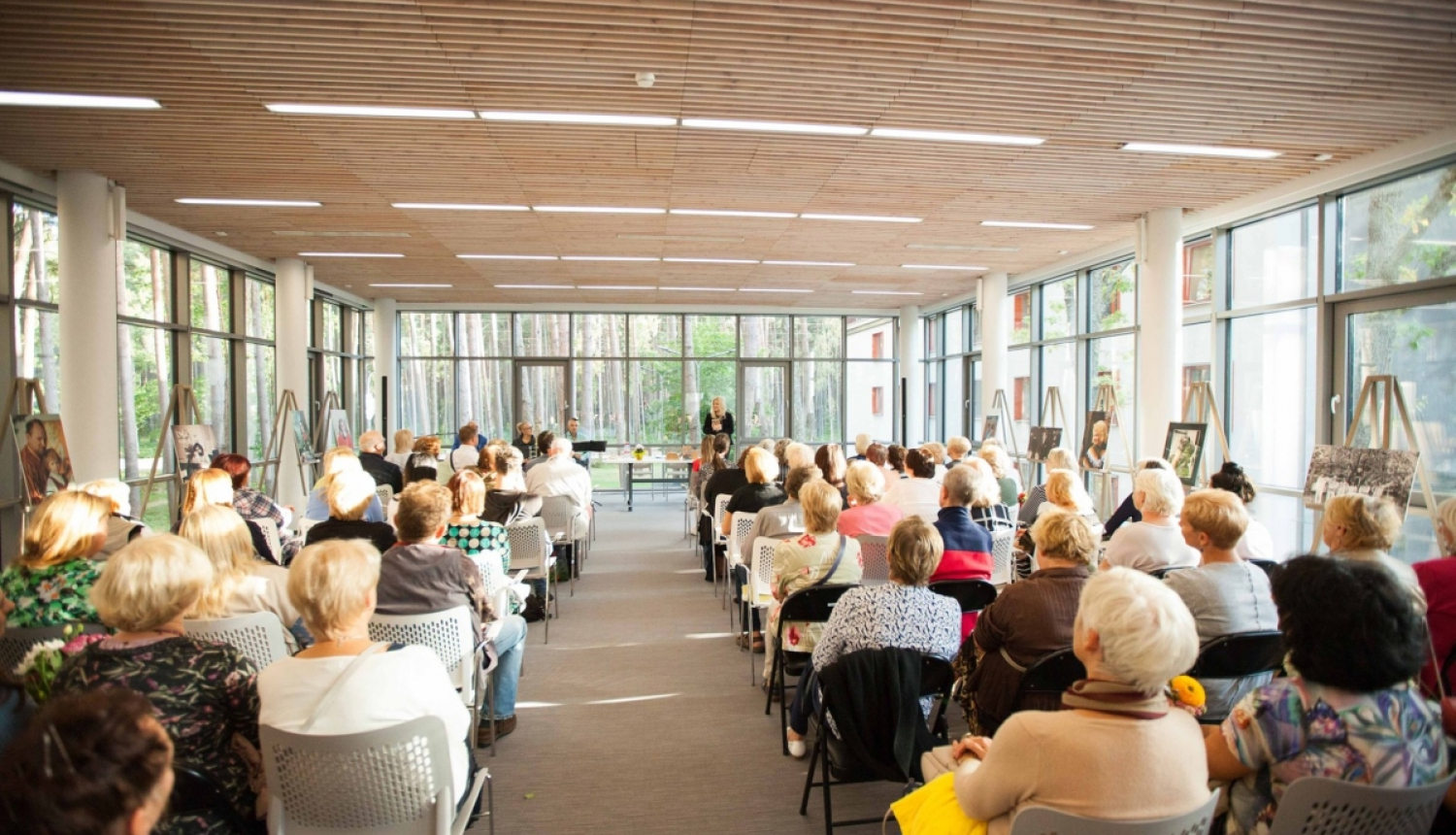 cilvēki klausās lekciju Jūrmalas centrālās bibliotēkas zālē