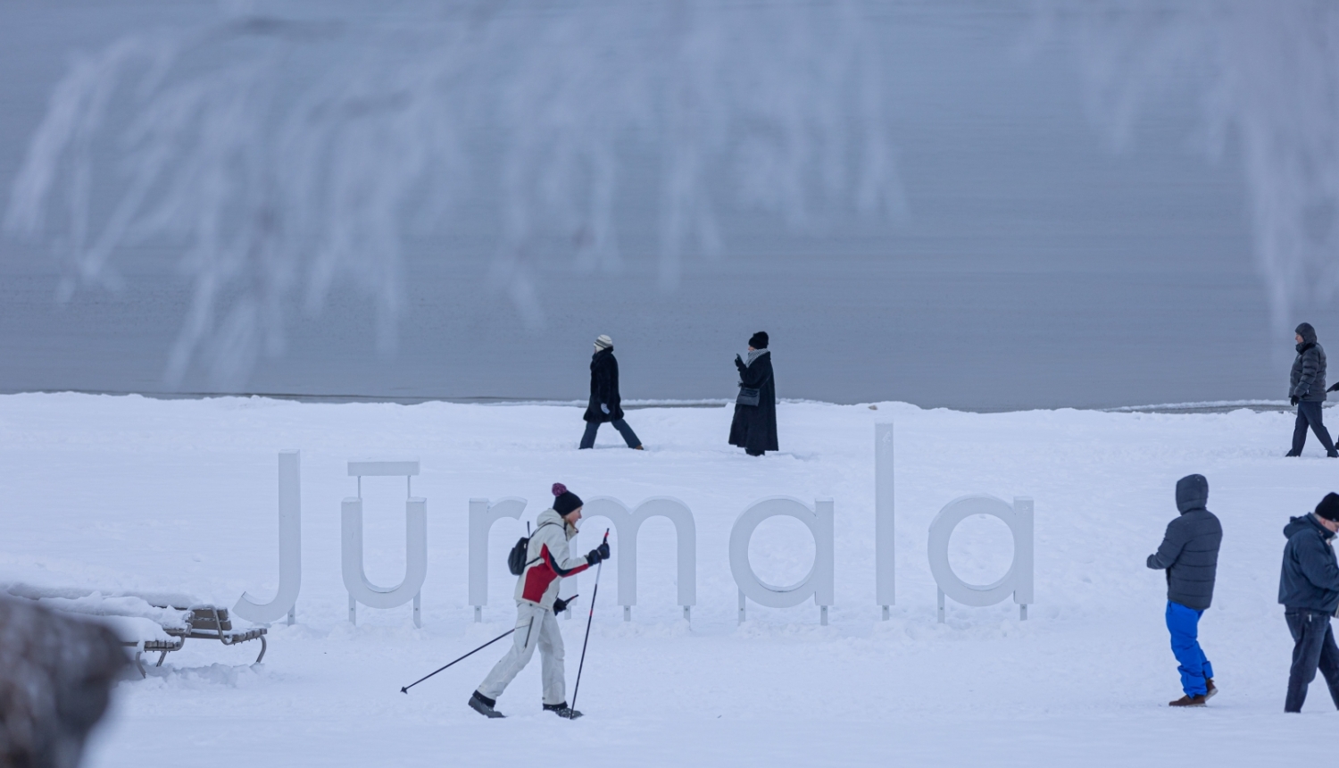 Ziema Jūrmalā, cilvēki pludmalē slēpo un pastaigājas